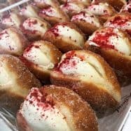 Delicious NZ donuts with creamy filling and raspberry topping.