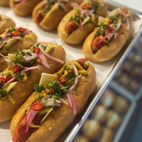 Savory hot dogs with fresh toppings at Knead Donuts, showcasing delicious street food options in NZ.