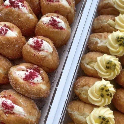 Close-up of freshly baked, decorated donuts from Knead Donuts, showcasing vibrant toppings and textures.