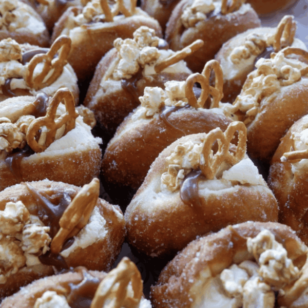 Delectable donuts topped with popcorn, pretzels, and caramel drizzle, ideal for satisfying your sweet tooth.