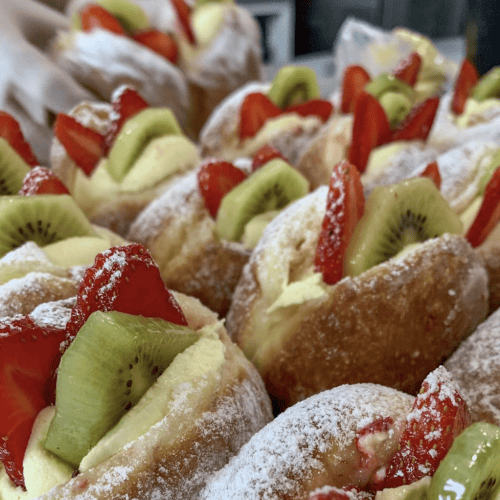 Delicious fresh donuts topped with strawberries, kiwi, and cream。 Perfect NZ sweet treat from Knead Donuts.