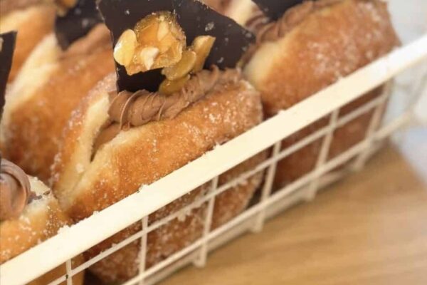 Delicious donuts topped with peanut chunks and chocolate pieces, perfect for peanut slab lovers.