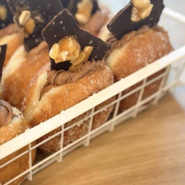 Delicious donuts topped with peanut chunks and chocolate pieces, perfect for peanut slab lovers.