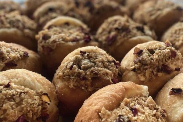 Delicious donuts topped with feijoa and apple crumble, perfect for a sweet treat. Freshly baked with.