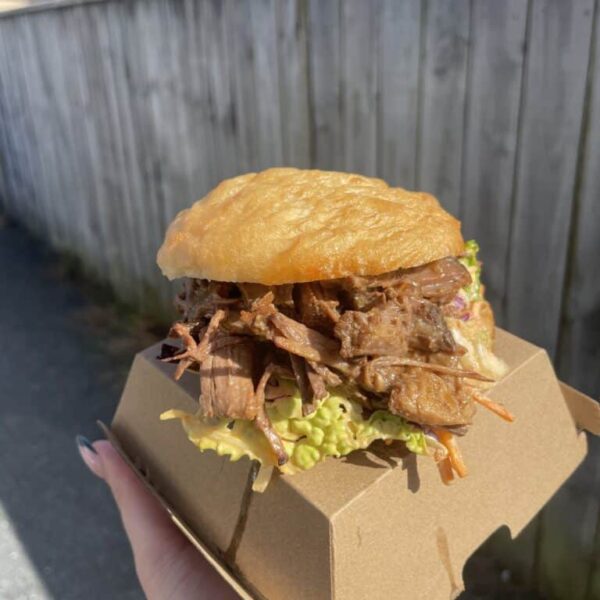 Delicious beef brisket in a soft donut bun with fresh lettuce, perfect for a savory treat.