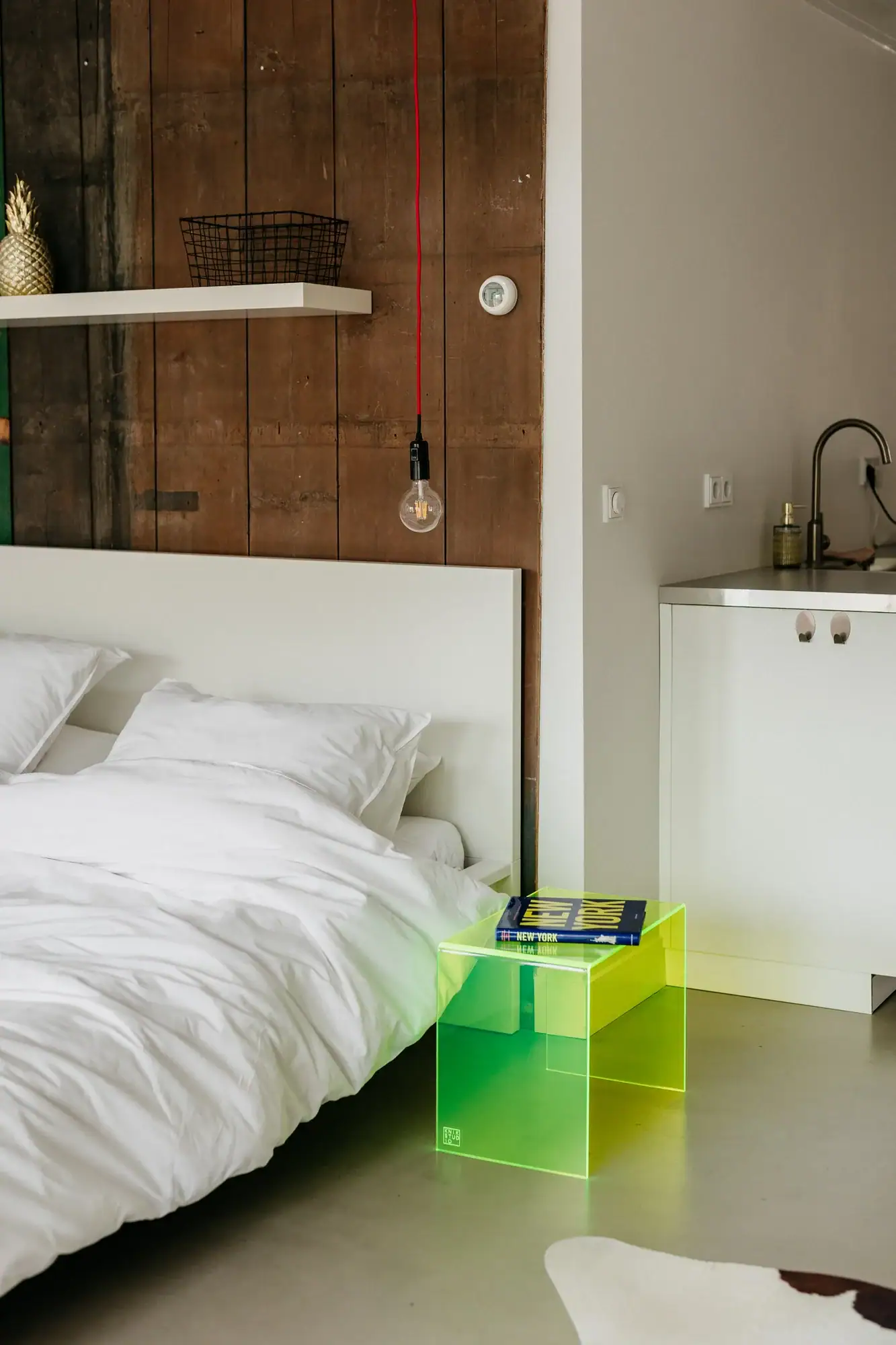 Moderne bijzettafel 'Iconic Glow' in heldere groene kleur naast bed.