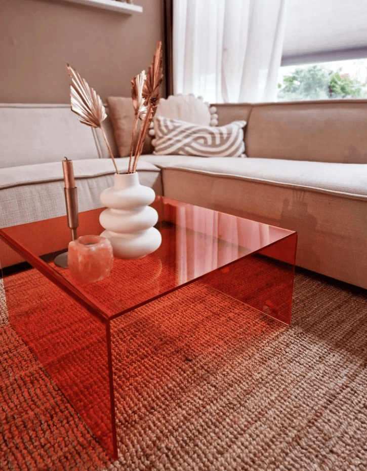 Moderne woonkamer met rode glazen salontafel en stijlvolle decoratie.