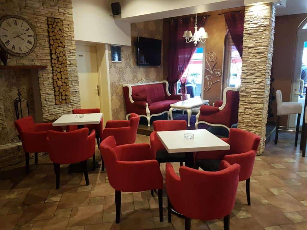 Elegantni enterijer Prenoćišta Lane Ključ s crvenim stolicama i kaminom