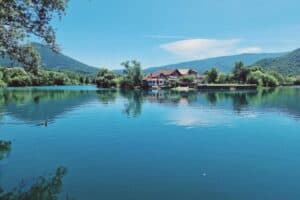 Pogled na kuću za odmor Šušnjar Ripač smještenu uz rijeku, okruženu planinama i prirodnim ljepotama.