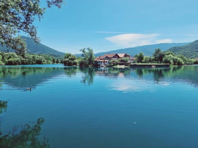Pogled na kuću za odmor Šušnjar Ripač smještenu uz rijeku, okruženu planinama i prirodnim ljepotama.