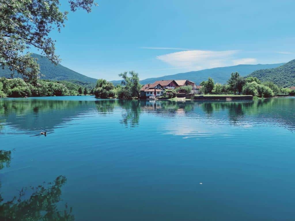 Pogled na kuću za odmor Šušnjar Ripač smještenu uz rijeku, okruženu planinama i prirodnim ljepotama.
