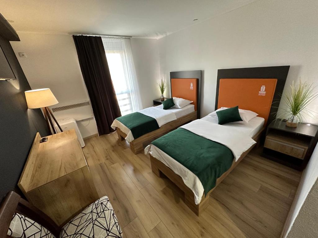Dvokrevetna soba u Hotelu Prijedor s modernim dizajnom, radnim stolom i udobnim krevetima
