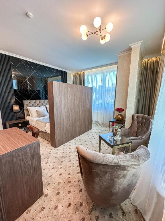Elegantna soba u Hotelu Vidović u Banjoj Luci, s modernim dekorom, udobnim krevetom i prostorom za sjedenje.
