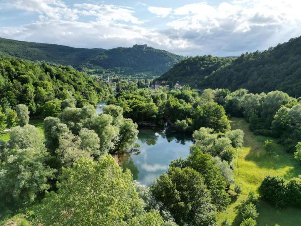 Slikoviti pejzaž Bosanske Krajine s rijekom, zelenilom i planinama.