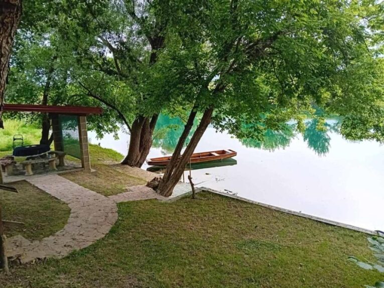 Mirno prirodno okruženje uz rijeku Unu u Natural Beauty UNA Bihać s čamcem i sjenicom za odmor.