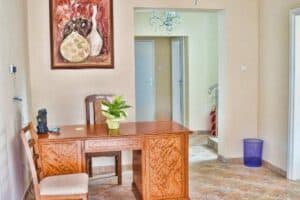 Recepcija u Hostelu Art Gradiška s elegantnim drvenim stolom i umjetničkim detaljima.