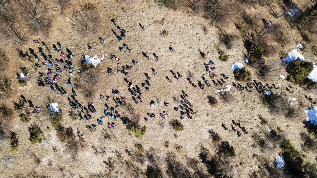 Zračna fotografija grupe planinara na prostranom pašnjaku Dimitora okruženom rijetkom vegetacijom.