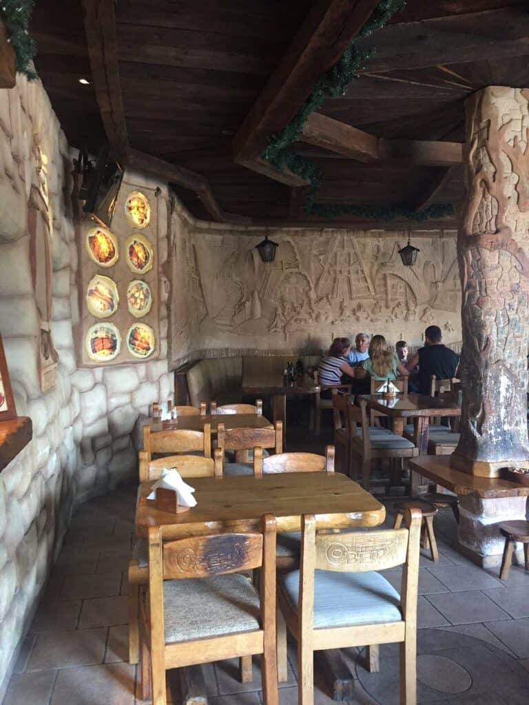 Unutrašnjost Obelix roštiljnice u Banjoj Luci s rustikalnim drvenim namještajem i dekoracijama na zidovima.