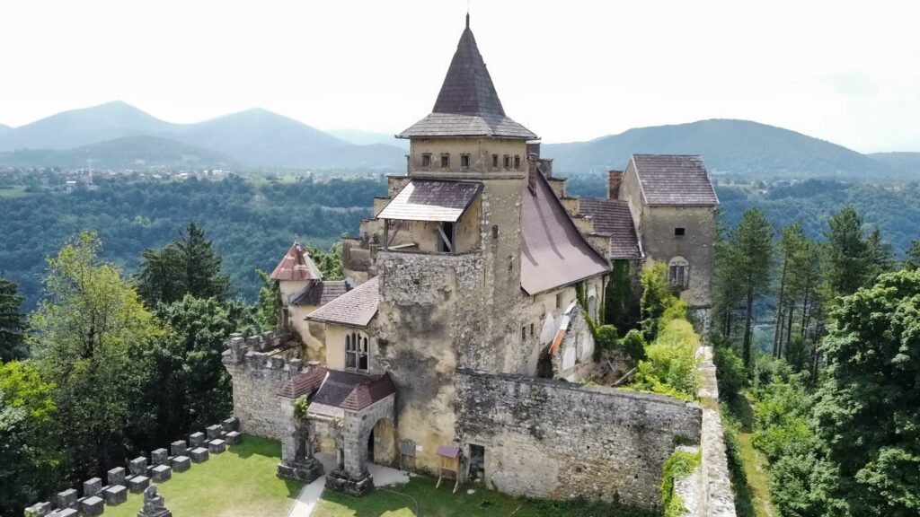 "Tvrđava Ostrožac u Cazinu, okružena zelenilom i planinskim pejzažima."