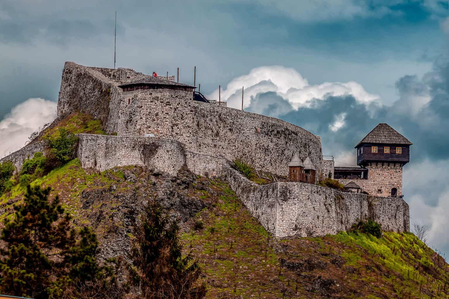 "Tvrđava Doboj na brežuljku, sa zadivljujućim pogledom na grad i okolne pejzaže."