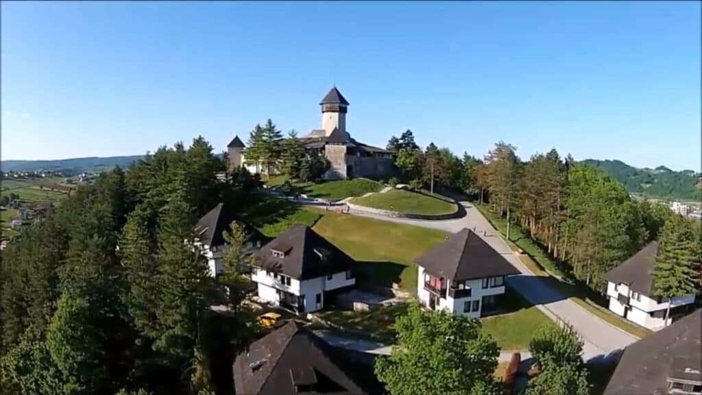"Tvrđava Velika Kladuša iznad grada, s pogledom na krajolik bogat zelenilom."