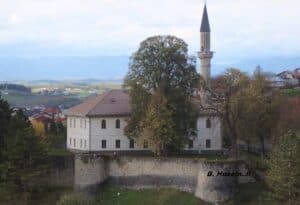 Sultanija Džamija u Cazinu, istorijski simbol grada, okružen zelenilom i smešten unutar starih zidina.