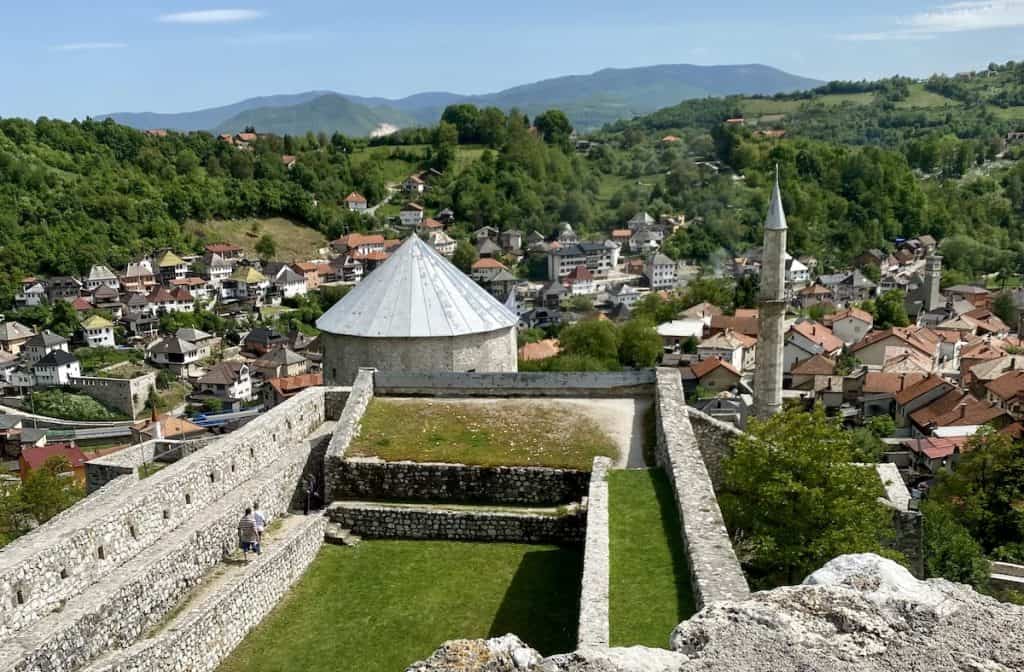 "Srednjovjekovna tvrđava u Travniku okruženom planinskim pejzažom."