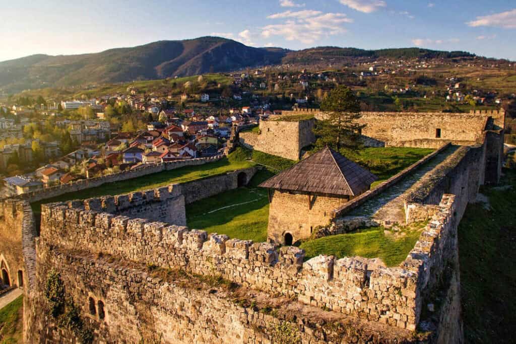 "Tvrđava Jajce iznad grada, s pogledom na Plivski vodopad i staro jezgro."