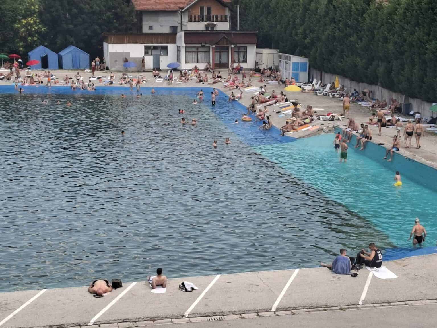 Ljudi uživaju u termalnom bazenu Banje Ilidža u Sarajevu, okruženi zelenilom i mirnim ambijentom.