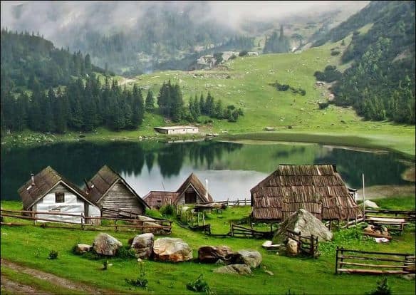 Prokoško jezero okruženo tradicionalnim drvenim kolibama i bujnom prirodom na planini Vranica.