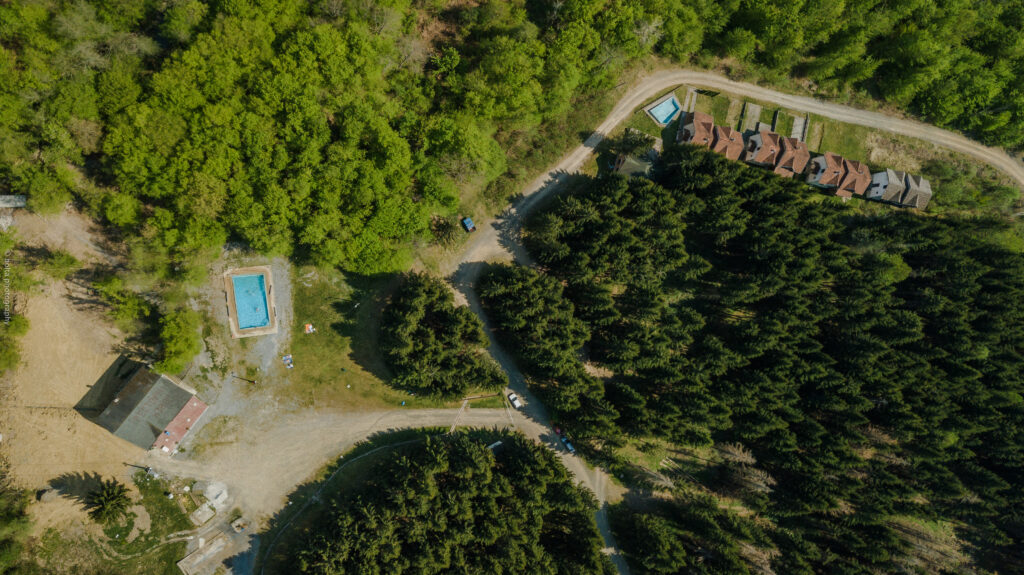 Aerijalni prikaz Banje Lješljani, okružene gustim šumama i prirodnim zelenilom, idealna za relaksaciju.