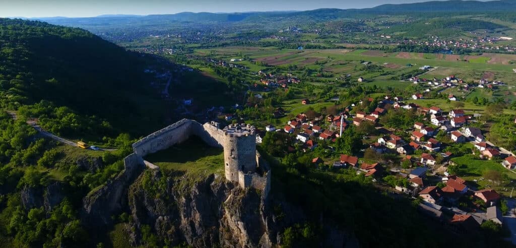 "Tvrđava Sokolac u Bihaću, okružena bujnom zelenom prirodom."