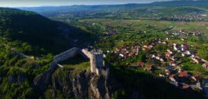 "Tvrđava Sokolac u Bihaću, okružena bujnom zelenom prirodom."