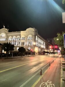 Noćna fotografija Banskog dvora u Banjoj Luci s osvijetljenom fasadom i praznom ulicom.