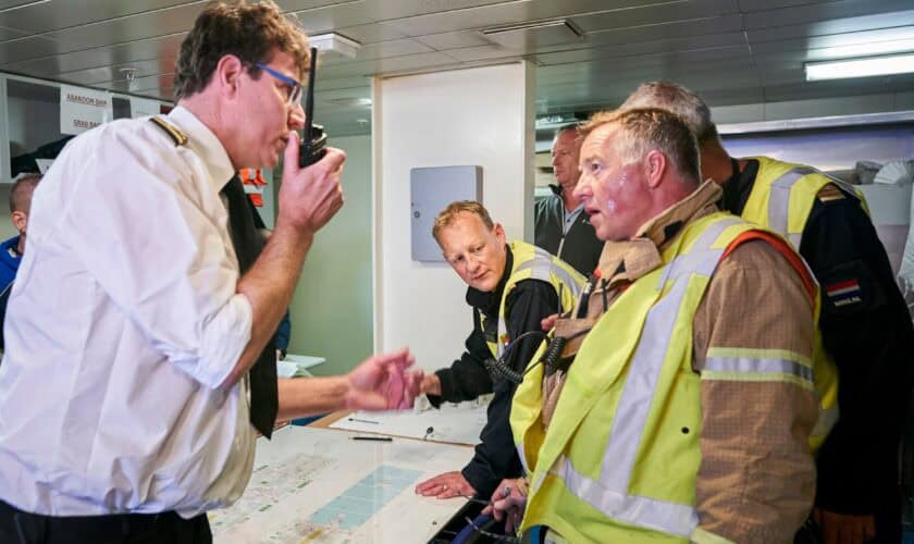 Brandweermensen praten op de brug met de kapitein