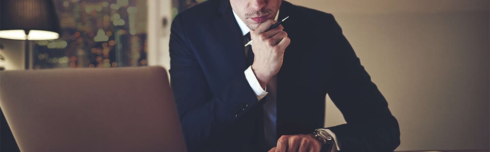 man in suit thinking at a table