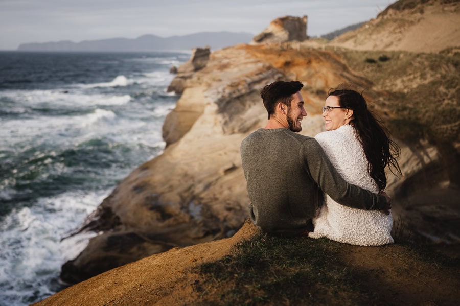 Couple smiling at each other over looking the Oregon Coast