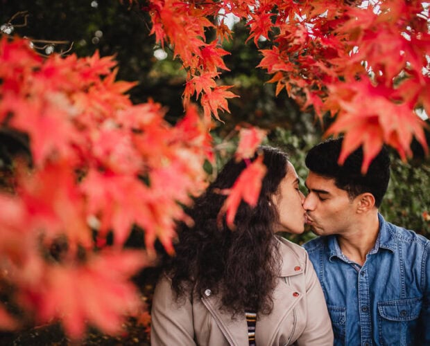 couple kissing in autumn foliage