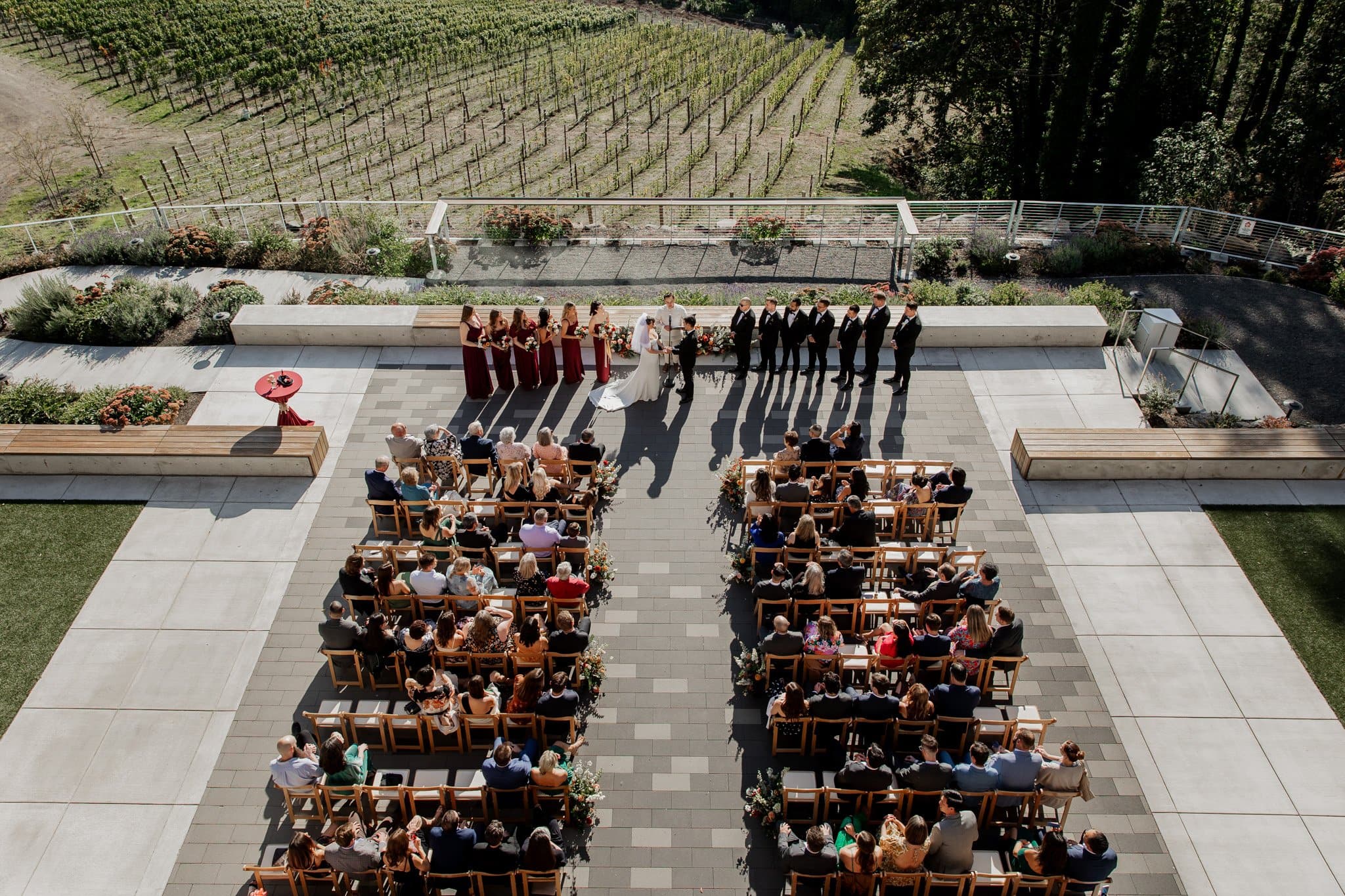 Outdoor wedding ceremony at Amaterra Winery, a picturesque Portland wedding venue, with guests seated and bridal party standing against the backdrop of lush vineyards.