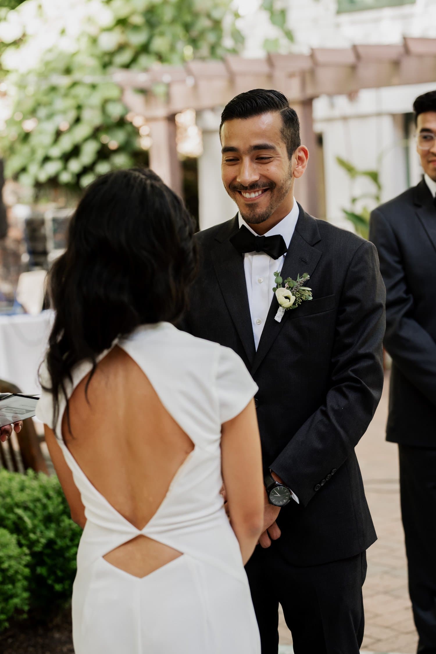 A couple smiling at each other during their outdoor wedding ceremony at Leach Botanical Garden.