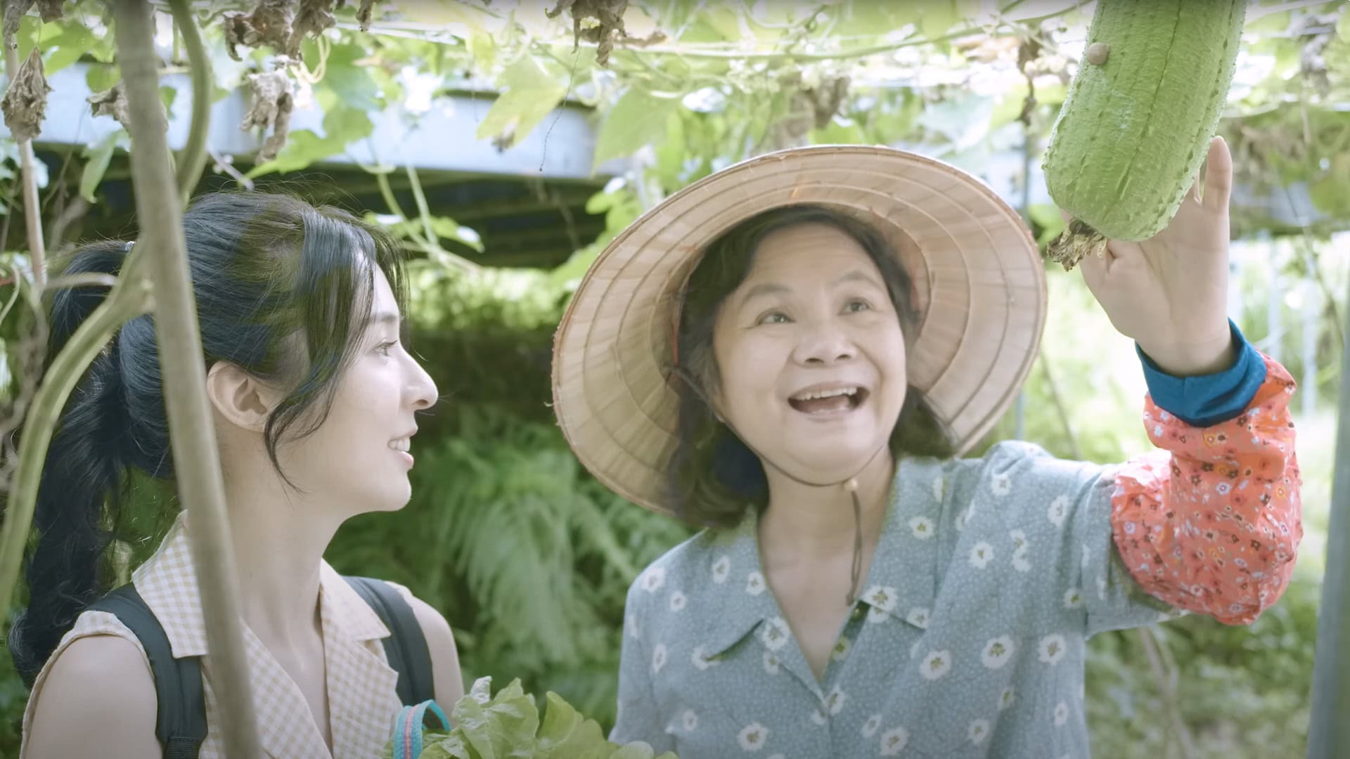 兩位女性在蔬菜棚架下開心互動，穿著傳統服飾，展現田園生活的溫暖氛圍｜台中市專業攝影｜奇力克影像工作室 KYRIC STUDIO 專業攝影