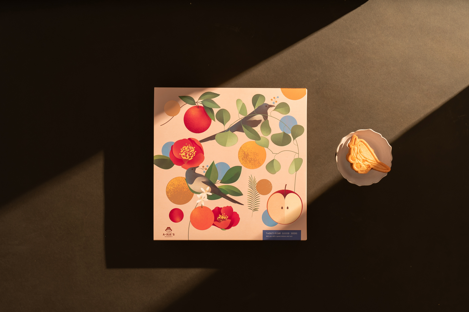 凝視溫暖光影中，Hanna illustration 的療癒插畫作品靜靜綻放——紅蘋果、柳橙與紅花交織成生活的詩意，旁伴一枚橘子果實，台中商攝專家奇力克影像工作室 KYRIC STUDIO 捕捉品牌的溫度與故事。
