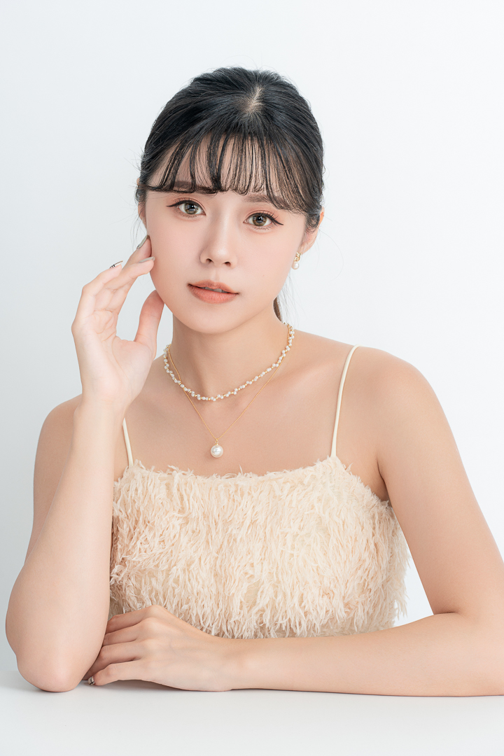 MINGMING 珍珠飾品形象拍攝｜中部專業商攝｜奇力克影像工作室 KYRIC STUDIO。年輕女性模特兒配戴珍珠項鍊與耳飾，穿著米色流蘇抹胸禮服，優雅氣質展現珍珠飾品的精緻質感與高級感，適合珠寶品牌商業宣傳使用。
