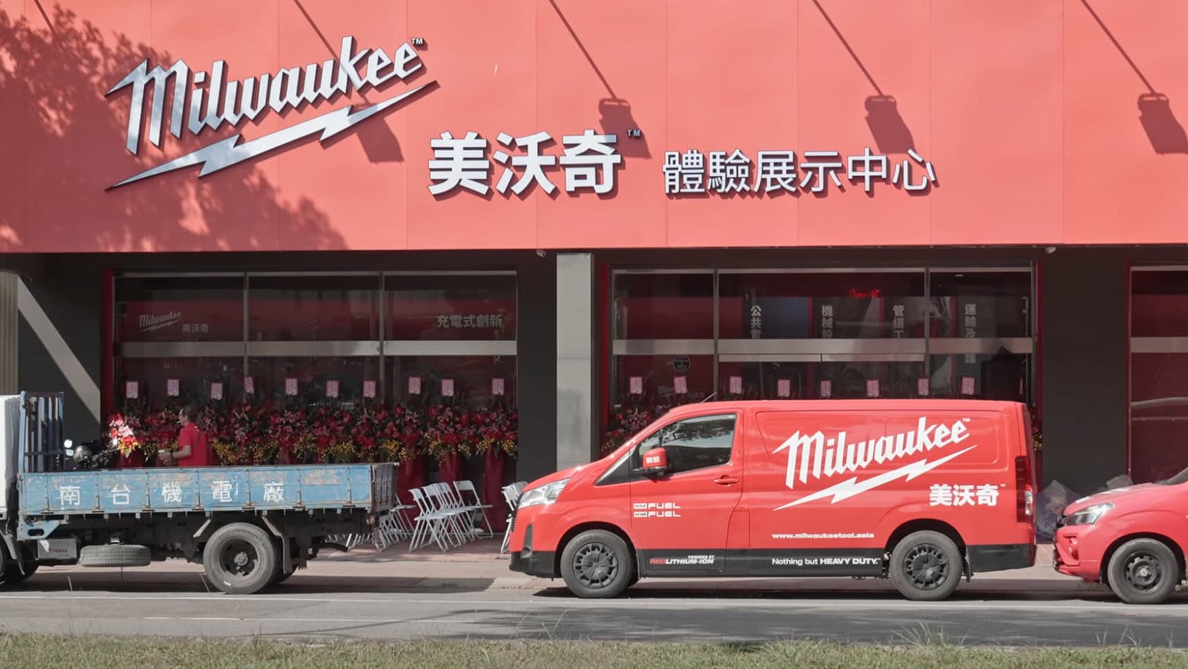 Milwaukee美沃奇體驗展示中心外觀，紅色品牌貨車停靠在門前，搭配大型招牌與花卉布置，展現企業形象與空間設計美感，為中部專業攝影公司奇力克影像工作室KYRIC STUDIO的影像作品。