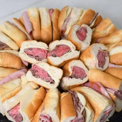 Assorted mini sandwiches on a platter for buffet or party.