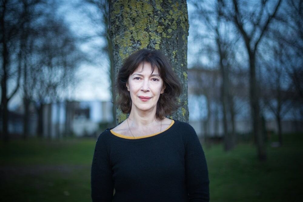 Naissance d'une femme en plein air devant un arbre lors d'une séance photo automnale.