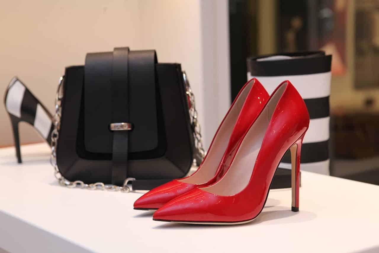 about-us-01 Showcasing sleek red stilettos and a chic black handbag in a luxury boutique setting.