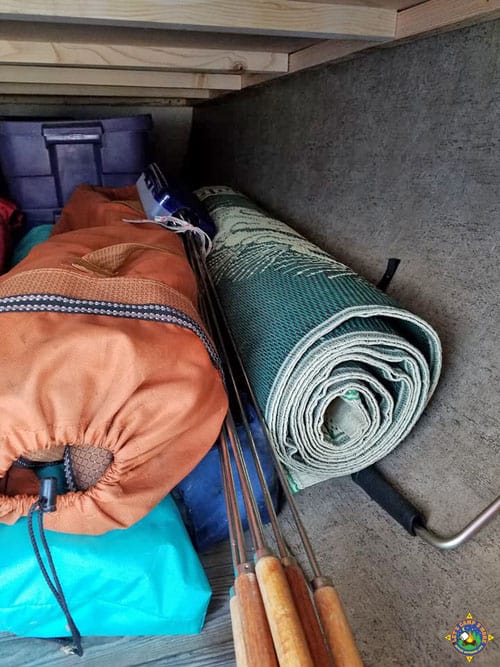 RV storage compartment filled with camping gear