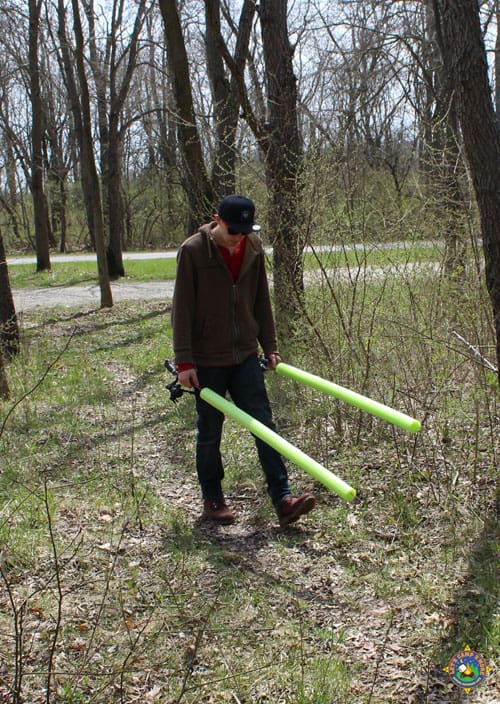guy walking with two fishing poles that look like light sabers