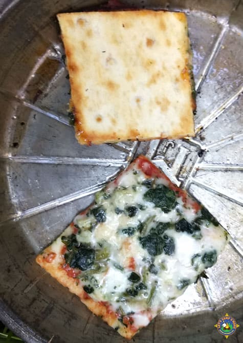 close up of 2 pieces of pizza made while camping